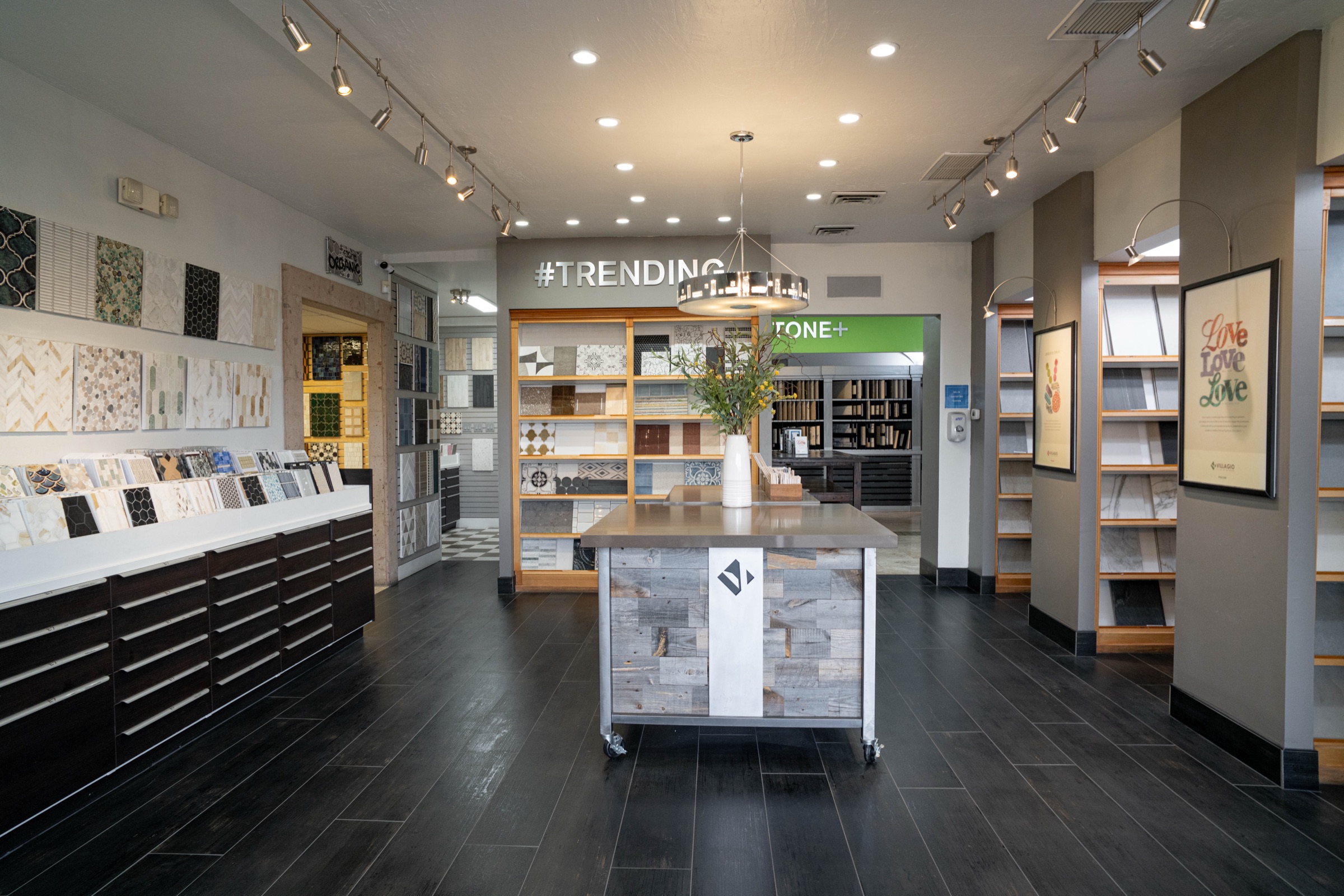 Wide view of the Villagio showroom floor, large format tile and stone slabs displayed under warm gallery lighting